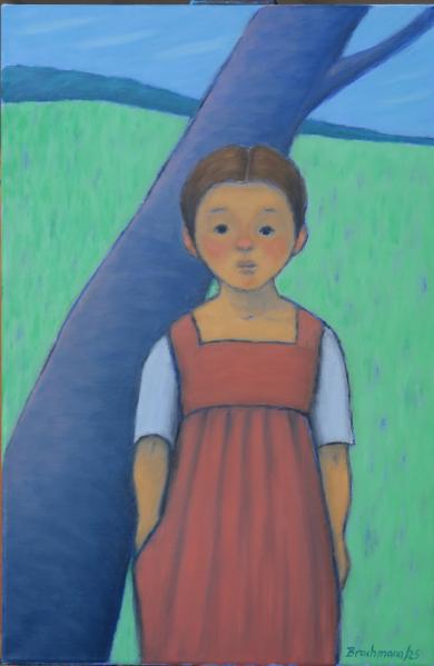 Mädchen vor einem Baum nach vorn schauend